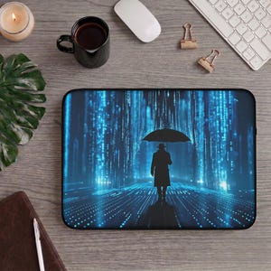 May include: A rectangular laptop sleeve featuring a digital print of a silhouette of a person in a trench coat holding an umbrella, standing amidst a vertical blue light matrix. The design displays a dark, glowing cybernetic aesthetic.