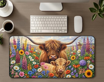 Könnte beinhalten: Eine rechteckige Schreibtischunterlage mit einer farbenfrohen Illustration eines Hochlandrindes und seines Kalbes auf einer lebendigen Blumenwiese mit Sonnenblumen, Lupinen und Gänseblümchen vor einem sanft beleuchteten Horizont.