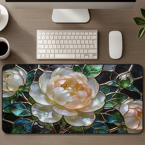 May include: A rectangular desk mat featuring a stained glass style design of three large, iridescent white and pale peach peony flowers. The floral pattern is accented with deep emerald green leaves and dark black marble-like segments.