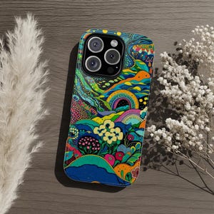 Pode incluir: Uma capa de telefone colorida com um design de paisagem psicodélica vibrante. A capa apresenta um arco-íris, flores e colinas onduladas em tons de azul, laranja, amarelo e rosa. A capa do telefone tem um módulo de câmera preto.