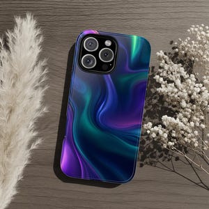 Könnte beinhalten: Eine Smartphone-Hülle mit einem fließenden, abstrakten Design aus wirbelnden Mustern in tiefem Violett, leuchtendem Türkis und Dunkelblau. Die Hülle verfügt über eine Aussparung für ein Dreifach-Kamerasystem in der oberen linken Ecke.