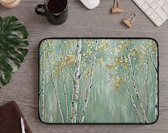 Könnte beinhalten: Eine rechteckige Laptoptasche mit einem Druckmotiv eines Waldes mit weißen Birken, salbeigrünen Blättern und goldfarbenem Laub. Zwei kleine Vögel sitzen auf den Ästen zwischen den Bäumen vor einem sanften grünen Hintergrund.