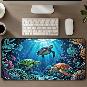 Puede incluir: Una alfombrilla de escritorio rectangular que presenta una vibrante escena submarina con tres tortugas marinas nadando entre coloridos arrecifes de coral, plantas acuáticas brillantes y peces pequeños sobre un fondo azul profundo.