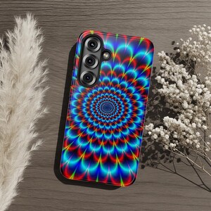 May include: A rectangular smartphone case featuring a vibrant, multi-colored psychedelic pattern of radiating, concentric petal-like shapes in shades of neon blue, bright red, and yellow, with a triple-lens camera cutout in the upper left corner.