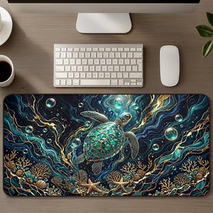 Puede incluir: Una alfombrilla de escritorio rectangular con una tortuga marina de caparazón con patrones en verde azulado y verde, nadando en agua azul oscuro con remolinos dorados, burbujas y formaciones de coral dorado con estrellas de mar.