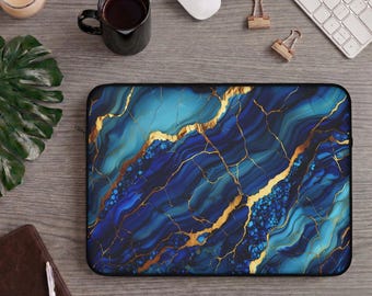 Könnte beinhalten: Eine rechteckige Laptoptasche mit einem lebendigen blau-türkisfarbenen Marmormuster und komplexen goldenen Adern. Das Design imitiert das Aussehen von poliertem Stein mit dunkelblauen, azurblauen und cyanfarbenen Wirbeln, die durch goldene Linien akzentuiert werden.
