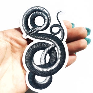 May include: A black and white snake sticker with a detailed design. The snake is curled up in a circle with its tail in its mouth.