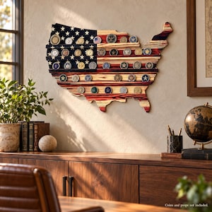 May include: A wall-mounted wooden display rack shaped like the map of the United States, featuring horizontal shelves for holding challenge coins. The wood is stained with a red, white, and blue flag pattern, with white stars on the blue section.