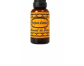 Peut inclure: Un petit flacon en verre ambré avec un bouchon à vis noir. L'étiquette est jaune avec des bordures décoratives noires et le texte noir Parfum d'amour et Aimant de Paris, avec un motif ovale.
