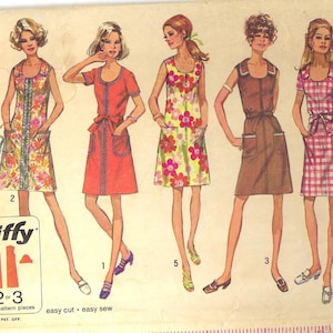 May include: A sewing pattern for a dress with four different styles. The pattern is from Simplicity and is number 8872. The pattern is for sizes 14 and 36. The dress is shown in four different colors: red, brown, yellow, and pink.