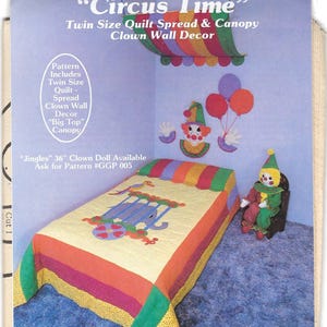 Peut inclure: Un ensemble de couette de taille double sur le thème du cirque. La couette présente une bordure rayée colorée et un panneau central avec un éléphant dans une cage. La canopée est en tissu arc-en-ciel et est suspendue au-dessus du lit. La décoration murale comprend un clown avec des ballons et une poupée clown.