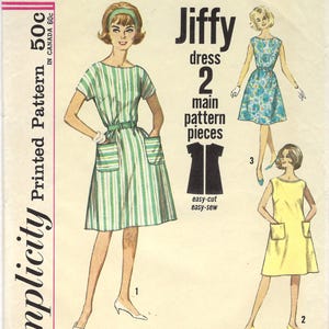 May include: Vintage Simplicity Jiffy dress pattern. The pattern shows illustrations of three dresses: a green and white striped dress, a blue floral dress, and a yellow dress. The pattern includes the text "easy-cut easy-sew".