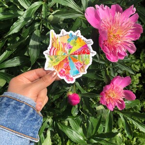 May include: A colorful round sticker with the text "Time spent in nature is time well spent." The sticker features a variety of nature scenes, including mountains, cacti, flowers, and a rainbow.