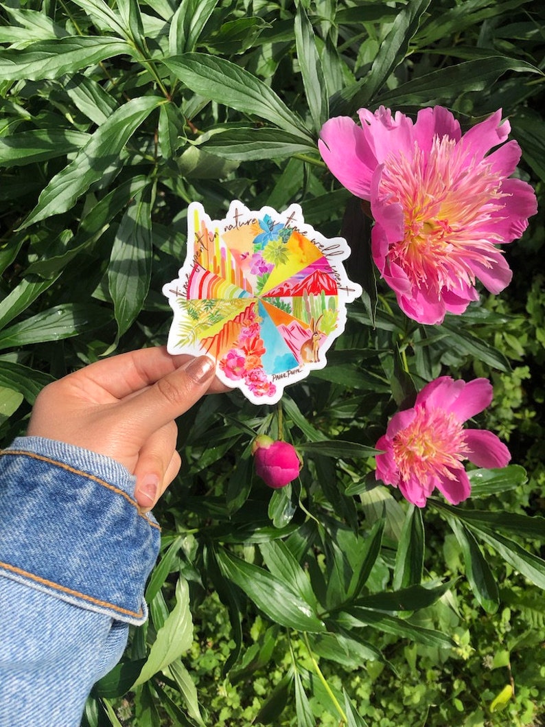 May include: A colorful round sticker with the text "Time spent in nature is time well spent." The sticker features a variety of nature scenes, including mountains, cacti, flowers, and a rainbow.