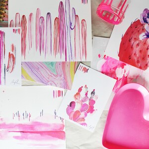 Puede incluir: Una colecci&oacute;n de pinturas de acuarela con cactus rosas y morados, un plato en forma de coraz&oacute;n rosa y una pintura de acuarela rosa y roja de un cactus con una flor.