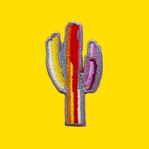 May include: A colorful embroidered cactus patch with a rainbow design. The cactus is outlined in gray and has a pink, red, orange, yellow, and white striped design.