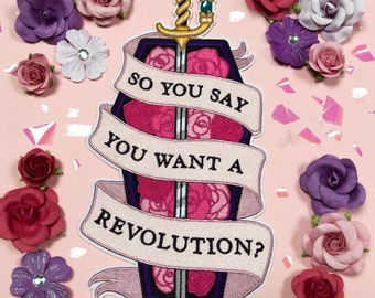 May include: A pink and white embroidered patch with a sword and a coffin. The text on the patch reads "So you say you want a revolution?"