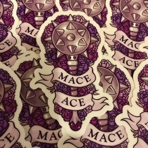 May include: A sticker featuring a purple and gray mace with a floral design. The mace has a spiked ball and a handle with a purple gem. The text "Mace Ace" is written on a banner around the mace.