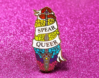 May include: A rainbow-coloured enamel pin with a spear and flowers. The pin says "Spear Queer" in white letters.