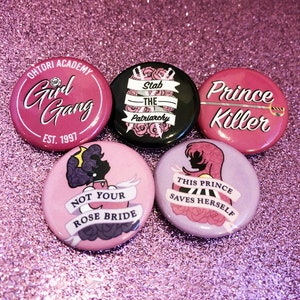 Könnte beinhalten: Fünf rosa, violette und schwarze Anstecknadeln mit feministischen Slogans. Die Nadeln zeigen Illustrationen von Rosen, Schwertern und einer Silhouette einer Frau. Der Text auf den Nadeln lautet: "Ohtori Academy Girl Gang Est. 1997", "Stab the Patriarchy", "Prince Killer", "Not Your Rose Bride", und "This Prince Saves Herself".