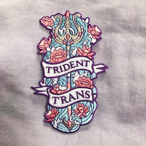 May include: A purple and blue embroidered patch with a trident, flowers, and the words "Trident Trans".