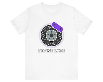 Könnte beinhalten: Ein weißes Kurzarm-T-Shirt mit einer Grafik eines dunkelgrauen, gelochten Bremsscheibenrotors mit einem violetten Bremssattel. Unter der Grafik ist der Text BRAKE LATE in einer fetten, serifenlosen Schrift auf der Brustmitte aufgedruckt.