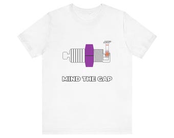 Könnte beinhalten: Ein weißes Kurzarm-T-Shirt mit einer Grafik einer Zündkerze mit violettem Mittelteil. Die Grafik zeigt einen kleinen orangefarbenen Funken und den Text .035" über dem Spalt, mit dem darunter gedruckten Schriftzug MIND THE GAP.