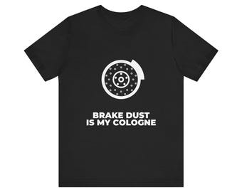 Könnte beinhalten: Ein schwarzes Kurzarm-T-Shirt mit einer weißen Grafik einer kreisförmigen Bremsscheibe mit Bremssattel. Unter der Grafik befindet sich der Text BRAKE DUST IS MY COLOGNE in einer fetten, weißen, serifenlosen Schrift mittig auf der Brust.