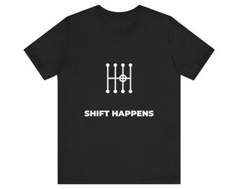Könnte beinhalten: Ein schwarzes T-Shirt mit kurzen Ärmeln und einer weißen Grafik eines manuellen Schaltmusters mit einem Kreis in der Mitte. Unter der Grafik ist der Text SHIFT HAPPENS in weißen Großbuchstaben aufgedruckt.