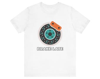 Könnte beinhalten: Ein weißes Kurzarm-T-Shirt mit einer Grafik eines schwarzen und blaugrünen gelochten Bremsscheibenrotors mit einem orangefarbenen Bremssattel. Unter der Grafik ist der Text BRAKE LATE in einer fetten, schwarzen serifenlosen Schrift gedruckt.