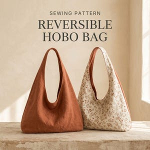 May include: A sewing pattern for a reversible hobo bag. The image displays two hobo bags: one in a solid terracotta colour and another featuring a cream fabric with a small brown floral print. The text reads SEWING PATTERN REVERSIBLE HOBO BAG.