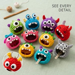 May include: A collection of ten colorful crocheted monster keychains with large plastic eyes and wide mouths. Each monster features unique horns, colors, and expressions. One gray monster holds a metal key, and the text SEE EVERY DETAIL is visible.