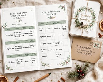 May include: A Christmas card address book and sent/received tracker with green headers and holly illustrations. Beside it sits a stack of Season's Greetings cards tied with twine, a kraft paper envelope addressed to Emily Watson, and a wooden pen.