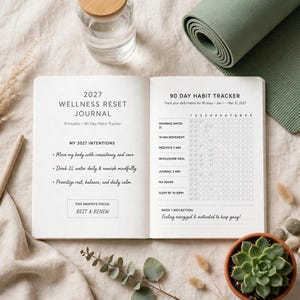 May include: An open 2027 Wellness Reset Journal with a 90-day habit tracker. The left page lists intentions and monthly focus, while the right page features a grid for tracking daily habits like water intake, movement, meditation, and sleep.