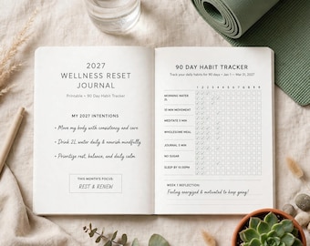 Op de afbeelding: Een open 2027 Wellness Reset Journal met een 90-dagen gewoonte-tracker. De linkerpagina bevat intenties en de maandelijkse focus, terwijl de rechterpagina een raster toont voor het bijhouden van dagelijkse gewoontes zoals water en slaap.