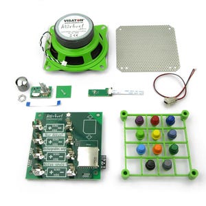 May include: A DIY electronics kit featuring a green Visaton speaker, a metal speaker grille, a green circuit board with battery slots labelled 'Nur Akkus!', a green button grid with twelve colourful buttons, a volume knob, and various electronic components.