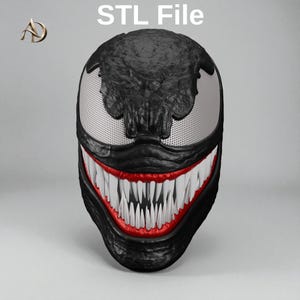 May include: A black 3D model of a creature head with large white mesh eyes, a wide mouth filled with sharp white teeth, and red gums. The text 'STL File' is printed at the top, and a logo with the letters 'AD' is in the upper left corner.