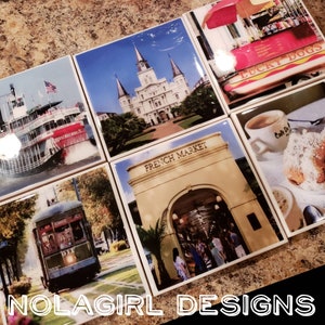 May include: Set of six colourful coasters featuring various New Orleans landmarks, including the French Market, St. Louis Cathedral, a streetcar, and a paddleboat. Each coaster has a glossy finish and features a different image of the city.