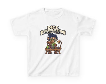 May include: A white t-shirt featuring a graphic of a character wearing goggles at a workbench with the text DICE REHABILITATION CLINIC. The character is repairing a large twenty-sided die with green magical energy, surrounded by smaller dice and a lamp.