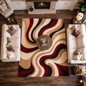 Könnte beinhalten: Ein rechteckiger Teppich mit einem wirbelnden, wellenförmigen Muster in den Farben Dunkelrot, Dunkelbraun, Hellbraun und Creme. Der Teppich liegt in der Mitte eines Raumes mit zwei beigen Sofas, einem runden Couchtisch und einem dunklen Holzboden.