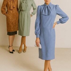 May include: Three women in knee-length dresses with bow details. The dresses are in shades of brown, green, and blue. The woman in blue holds a small white clutch. The models are wearing heels.