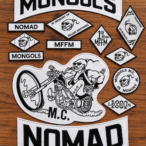 Może przedstawiać: Kolekcja biało-czarnych haftowanych naszywek z napisami MONGOLS, NOMAD, MFFM oraz 1%er MFFM. Zestaw zawiera naszywki w kształcie rombów, okrągłe i zakrzywione, z dużą centralną naszywką przedstawiającą postać jadącą na motocyklu.