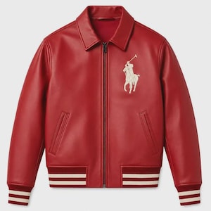 May include: A red leather bomber jacket featuring a classic collar, a full-length front zipper, and two slanted side pockets. The chest displays an embroidered white logo of a polo player on a horse. The cuffs and hem are ribbed with white stripes.