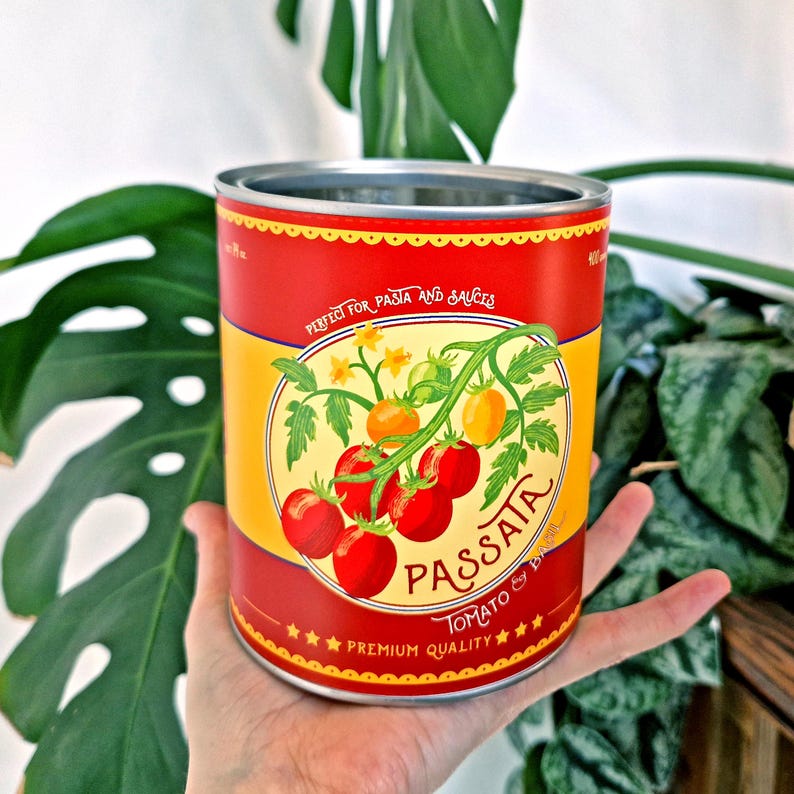 May include: A red and yellow can of Passata tomato sauce. The can features a tomato vine illustration with ripe red tomatoes and the text "Perfect for Pasta and Sauces". The can is held in a person's hand.