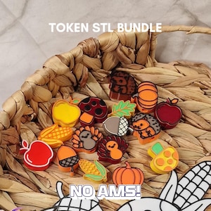 May include: A collection of small, colorful 3D-printed tokens featuring autumn-themed shapes like pumpkins, corn, apples, mushrooms, turkeys, and hedgehogs. The text "DOWNLOAD NOW", "TOKEN STL BUNDLE", and "NO AMS!" is visible.