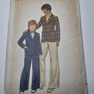May include: Butterick sewing pattern 4083, size 7. The envelope features an illustration of a child in a blue suit with a bow tie and an adult in a plaid blazer, yellow turtleneck, and light-colored trousers. Text includes Butterick, 4083, $1.00, and Canada $1.10.