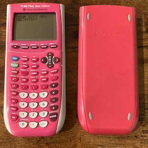 May include: A pink and white TI-84 Plus Silver Edition graphing calculator with a digital screen displaying the text CHATGPT, alongside its matching solid pink protective cover featuring the Texas Instruments logo embossed on the back.