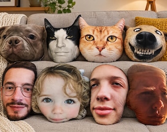May include: A collection of eight shaped throw pillows featuring realistic, high-resolution photographic prints of various human and animal faces, including a dog, a cat, a person with glasses, a child, and other distinct facial features.