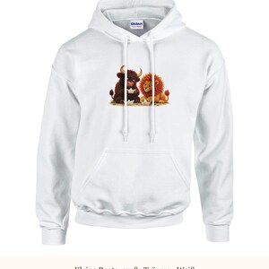 K&ouml;nnte beinhalten: Ein wei&szlig;er Kapuzenpullover mit langen &Auml;rmeln und einem Grafikdruck, der einen braunen Stier und einen goldenen L&ouml;wen zeigt, die zusammensitzen und mit kleinen wei&szlig;en Papierbooten spielen. Der Hoodie hat eine K&auml;ngurutasche und wei&szlig;e Kordeln.