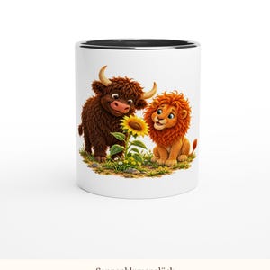 May include: A white ceramic mug with a black interior rim featuring a colorful illustration of a brown highland cow and a golden lion cub standing together in a grassy field with a single bright yellow sunflower between them.